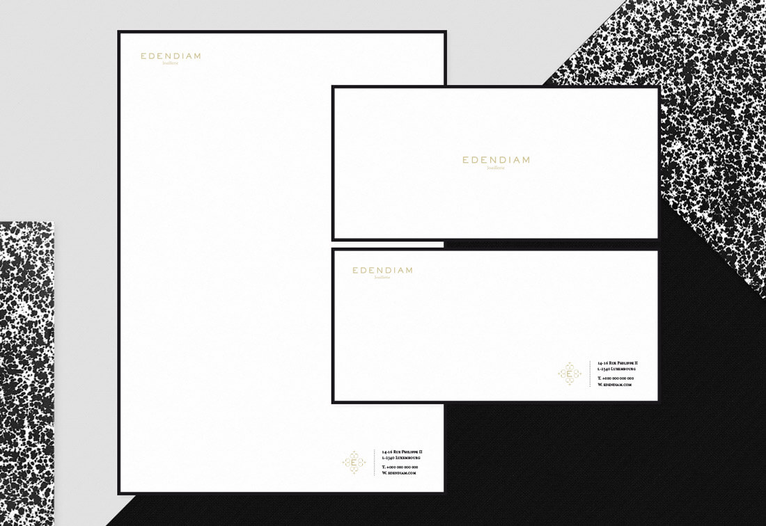 Un ensemble d'articles de papeterie minimaliste et moderne comprenant un papier à en-tête et deux enveloppes - idéal pour la création de catalogue - comportant le texte "EDENDIAM" en or et les coordonnées en noir, disposés sur un fond géométrique noir, blanc et moucheté.
