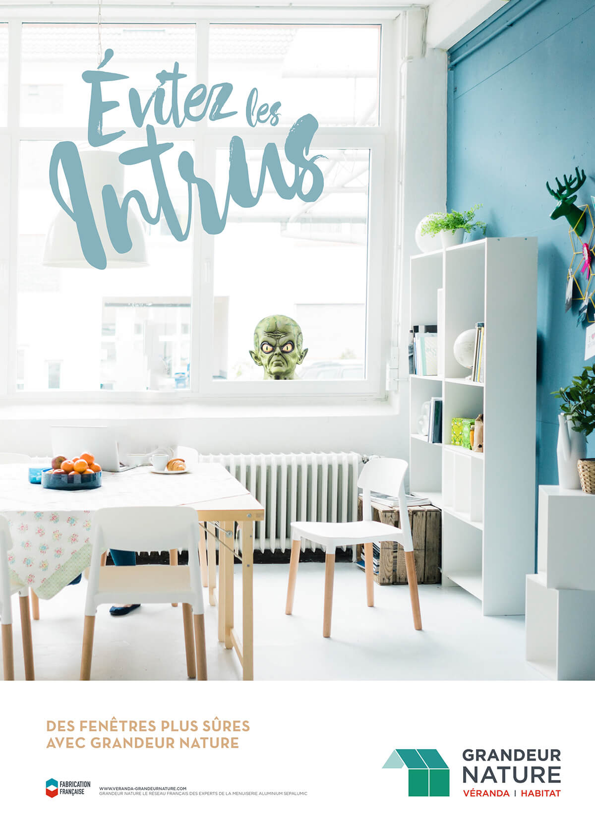 Une cuisine et une salle à manger modernes et lumineuses, avec une tête d'extraterrestre verte qui regarde par la fenêtre, illustrant l'importance de la communication en réseau. Un texte en gros caractères indique "Evitez les Intrus". Un logo et un slogan pour les fenêtres Grandeur Nature apparaissent en bas.