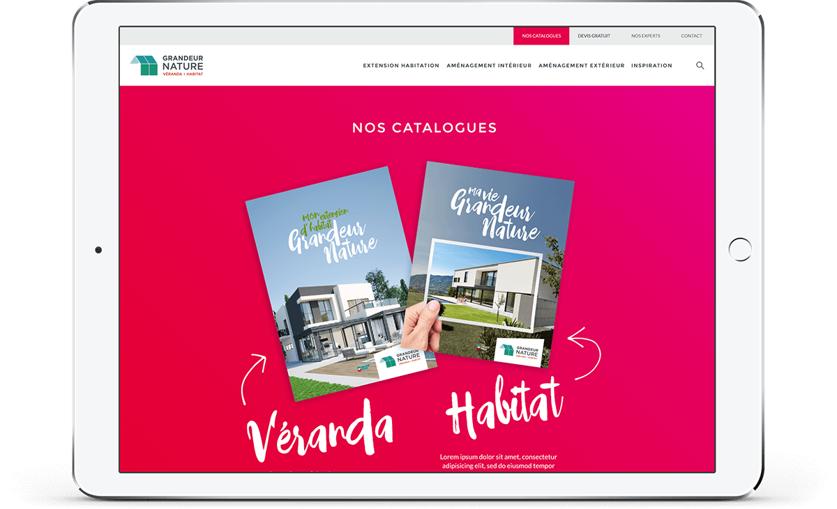 Un iPad affiche un site web sur fond rose vif montrant deux catalogues de conception de maisons intitulés "Ma Vie Grandeur Nature", présentant des maisons modernes, et portant les mentions "Véranda" et "Habitat", mettant en évidence un réseau de communication sans faille.