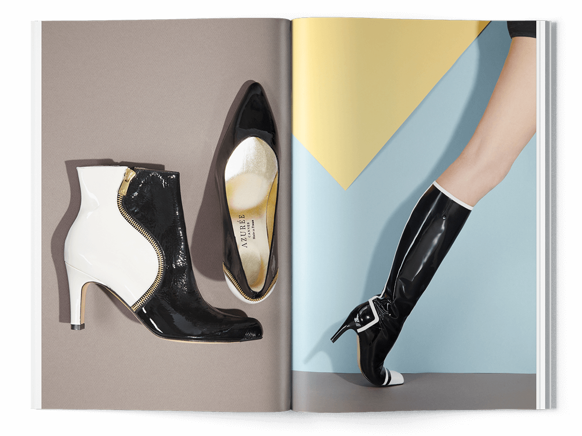 Un magazine de mode ouvert, faisant partie d'une création de catalogue, présente des chaussures à talons hauts en noir et blanc sur la page de gauche, et la jambe d'un mannequin dans une botte au genou assortie sur la page de droite, sur un fond géométrique.