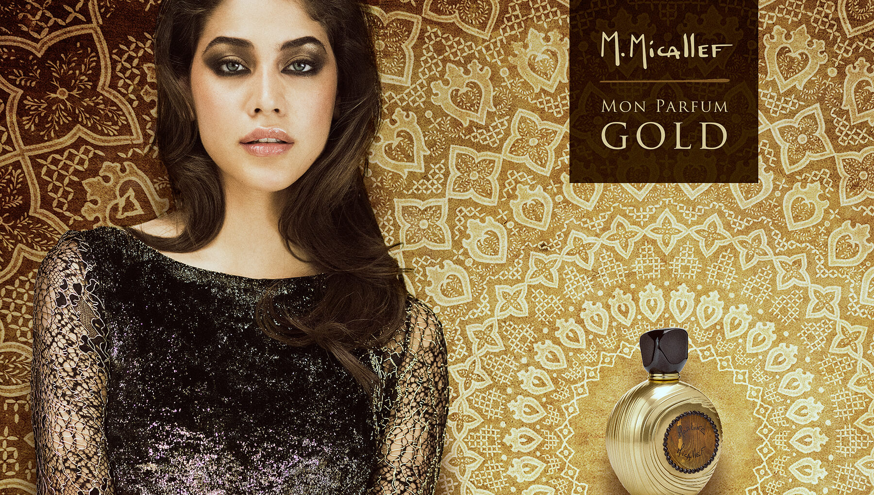 Une femme vêtue d'une robe en dentelle noire se tient à côté d'un fond à motifs dorés et d'un flacon de parfum rond et doré. La scène évoque la création d'un catalogue, soulignant l'élégance et le luxe de "M. Micallef Mon Parfum Gold".