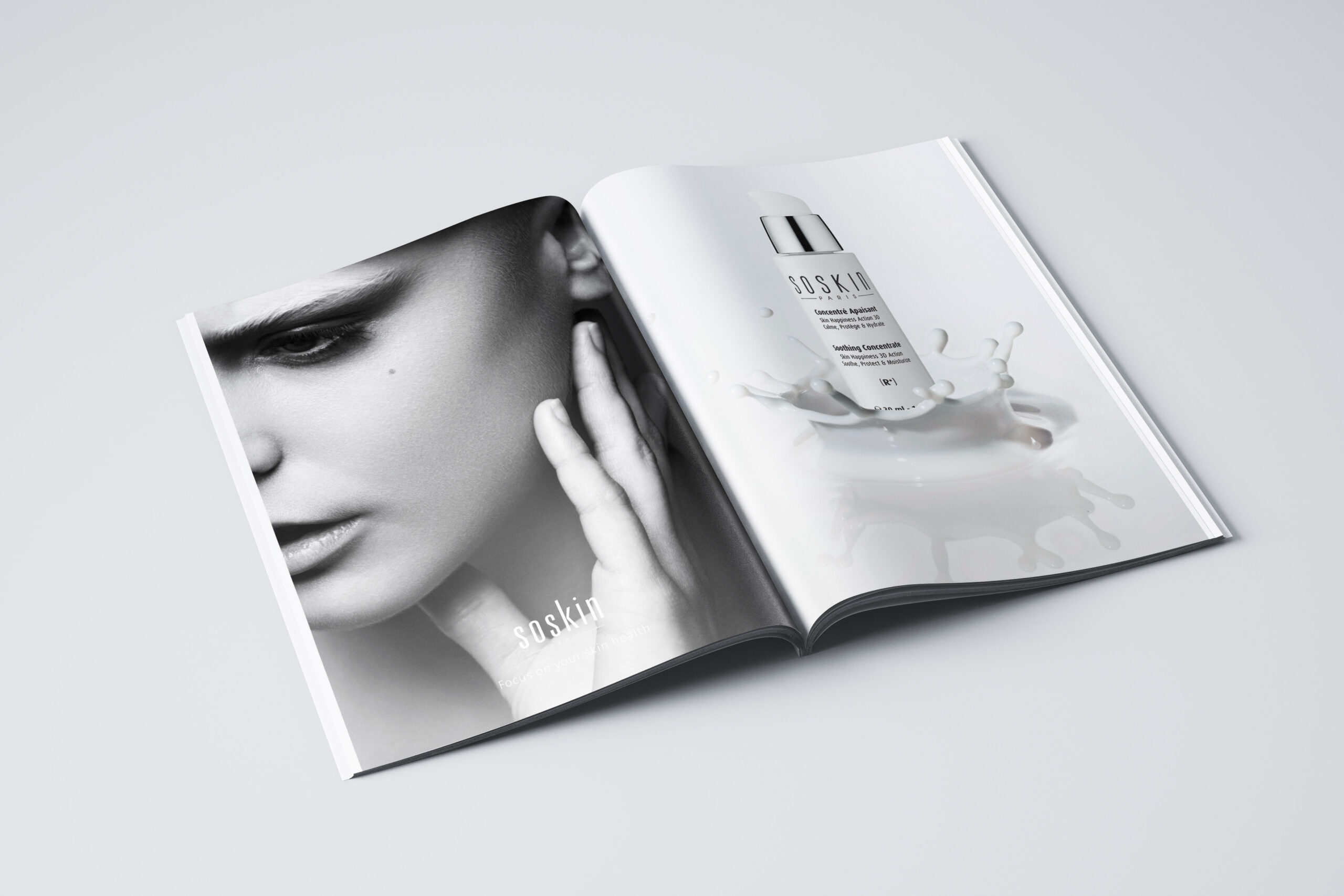 Un magazine ouvert - présentant un portrait de femme en noir et blanc et un produit de soin Soskin éclaboussé par un liquide blanc - capture l'essence de la création de catalogue avec des visuels frappants et une marque élégante.