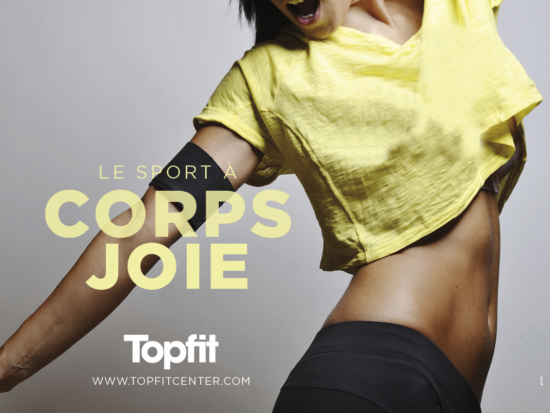 Une femme vêtue d'un haut jaune et d'un short noir prend une pose énergique, dévoilant son ventre tonique. Le texte se lit comme suit : "Le sport à corps joie" : "Le sport à corps joie", mettant en valeur la marque Topfit avec le logo et le site web ci-dessous.