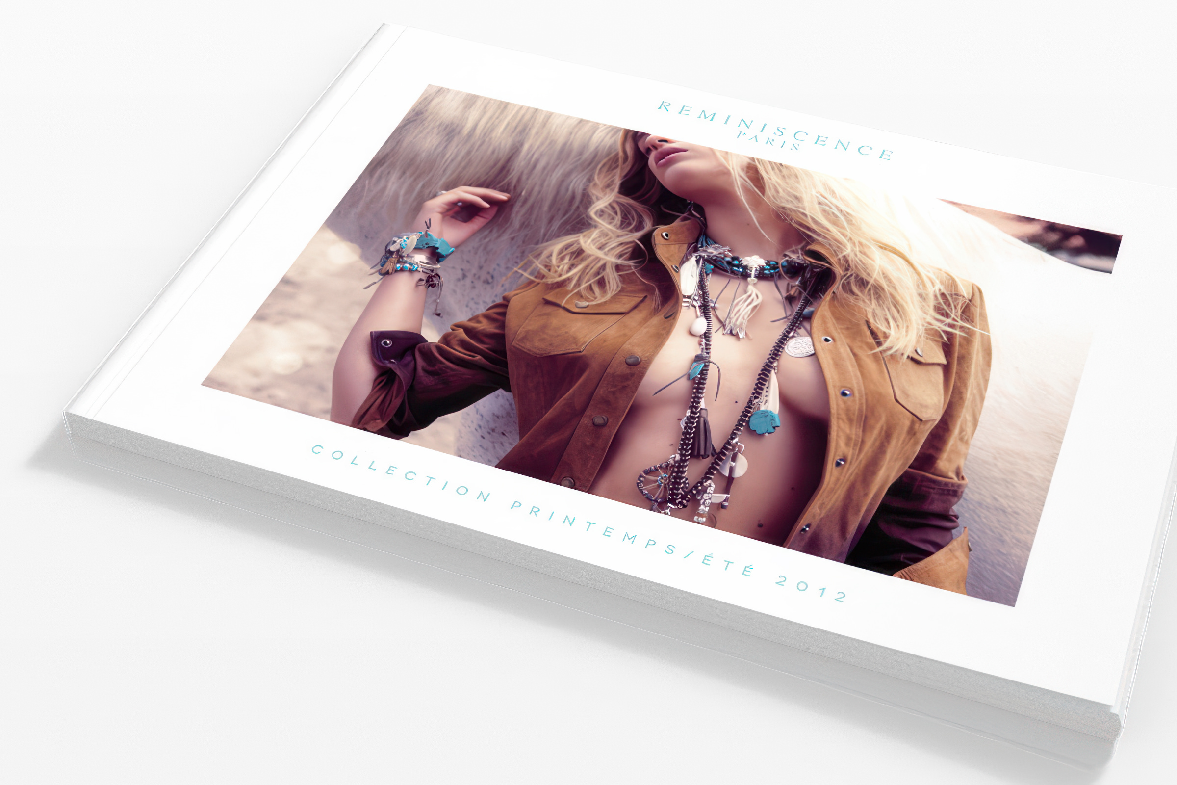 Un catalogue de mode intitulé "Reminiscence Paris" montre une femme blonde vêtue d'une veste brune et portant des bijoux colorés. La couverture indique "Collection Printemps/Été 2012" et présente une esthétique lumineuse et élégante.
