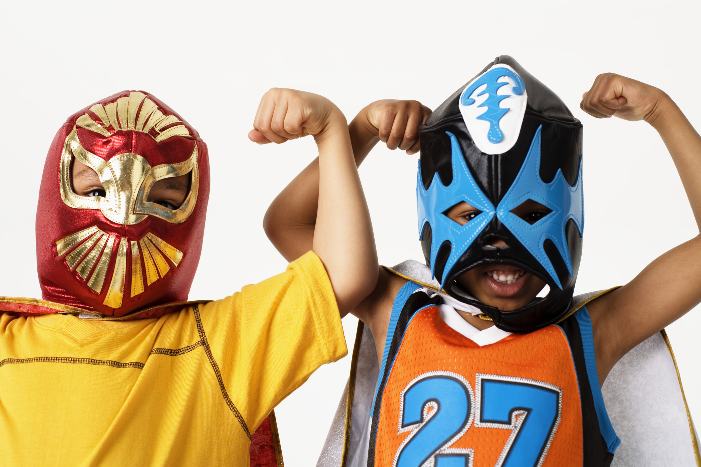 Deux enfants portant des masques et des costumes de lutte colorés sourient et fléchissent les bras, montrant leurs muscles, prêts à relever n'importe quel défi - comme des champions du webmarketing - sur un fond blanc uni.