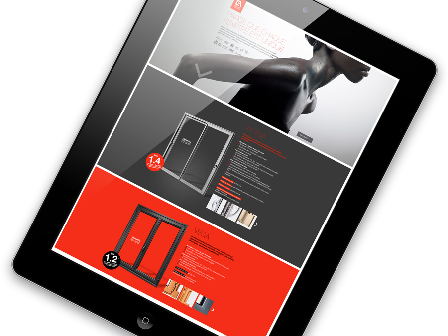 Une tablette noire affiche un site web moderne contenant des images et des informations sur les fenêtres et les portes, reflétant une création charte graphique avec des sections en rouge, blanc et gris, et une image partielle de la partie supérieure du corps d'une personne en haut.