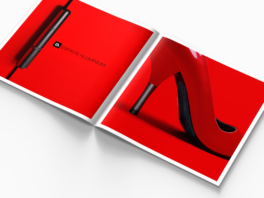 Un magazine ouvert sur une surface blanche met en évidence la création charte graphique, avec un gros plan sur une chaussure à talon haut rouge en face d'une charnière de porte noire avec "ESPACE ALUMINIUM" sur un fond rouge vif.