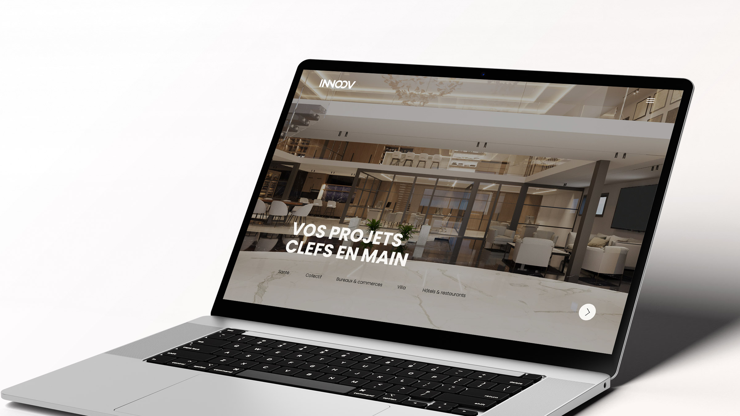 Un ordinateur portable affiche un site web au design intérieur moderne avec le texte français "VOS PROJETS CLEFS EN MAIN". L'en-tête indique "INNOV", reflétant l'expertise d'une agence de communication b2b. La scène se déroule sur un fond clair.