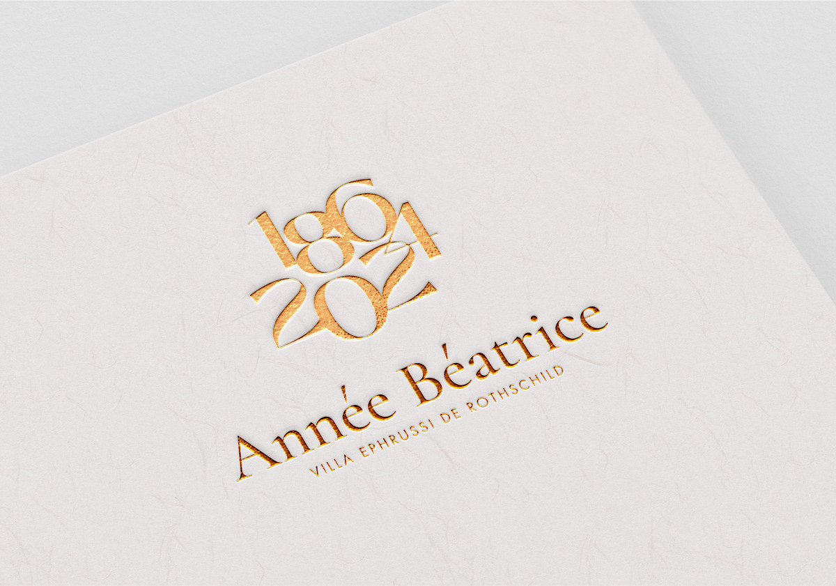 Le texte en or gaufré sur papier texturé clair indique "1864 2021" au-dessus de "Année Béatrice" et "Villa Ephrussi de Rothschild". Cette conception élégante et minimaliste est un exemple de création d'identité de marque raffinée.