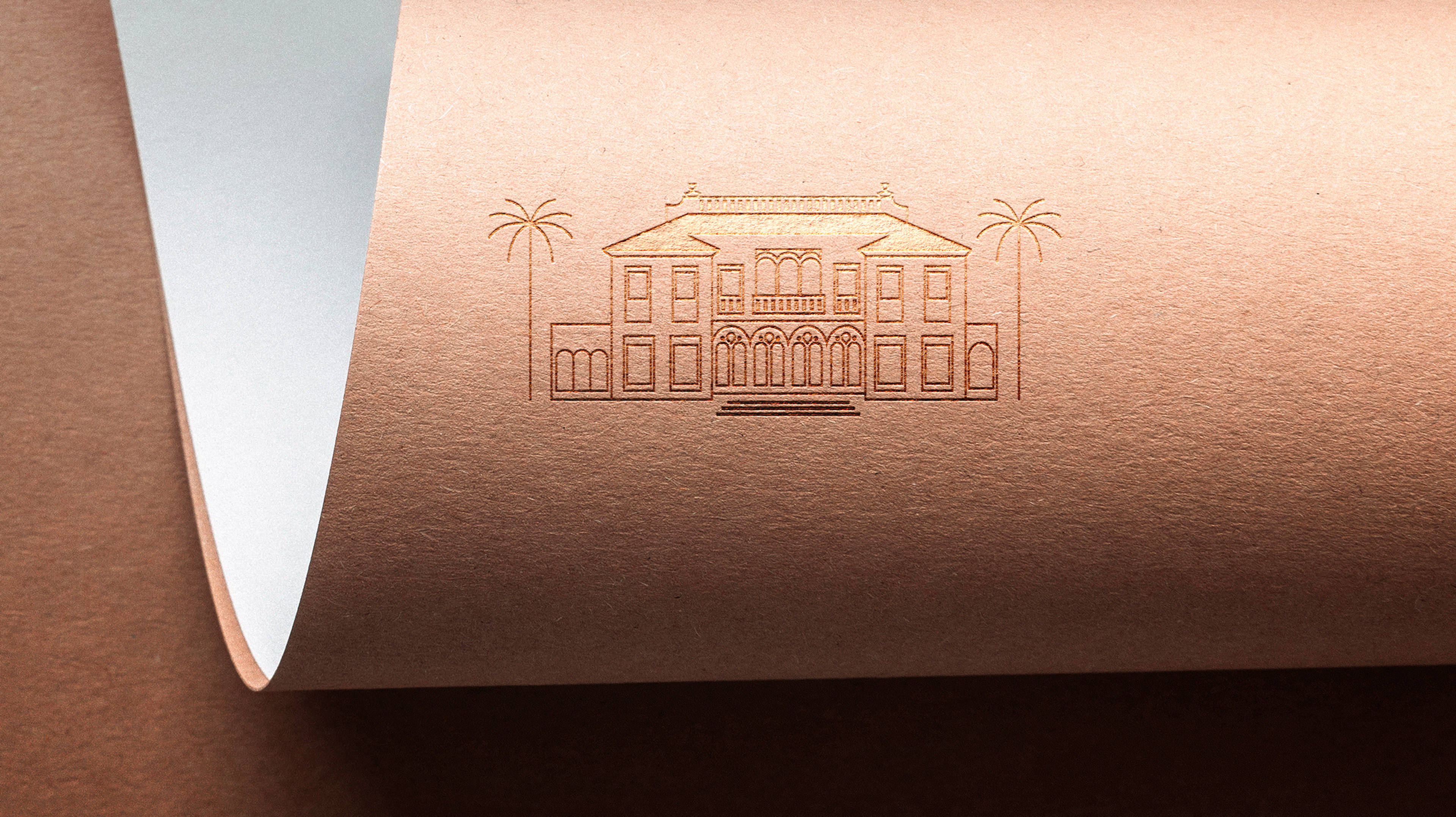 Une feuille de papier brun texturé présente un dessin en relief d'un grand bâtiment élégant avec des arcs, des colonnes et deux palmiers de chaque côté - une touche artistique pour toute création d'identité de marque. Le coin du papier est légèrement gondolé.