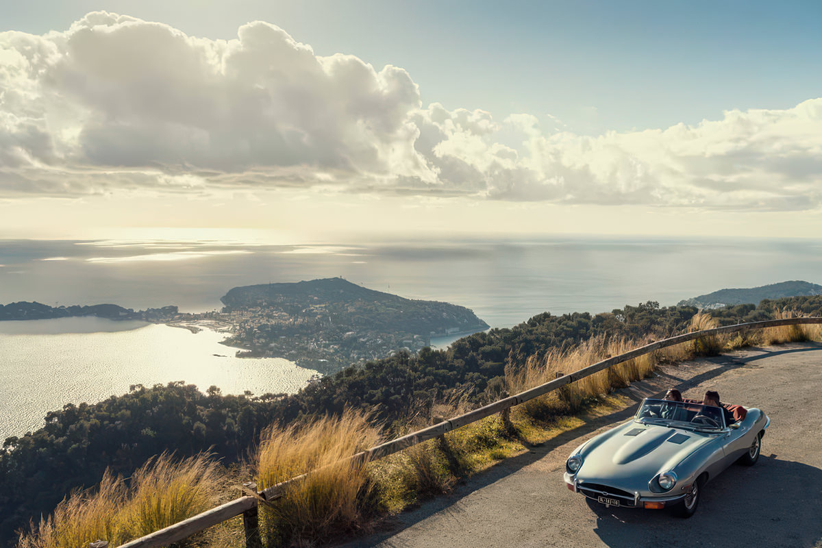 Vue aérienne d'une villa côtière au toit de tuiles rouges, entourée d'une végétation luxuriante et d'une piscine, au bord d'une mer d'un bleu limpide - une inspiration idéale pour votre projet de développement de site web sur mesure.