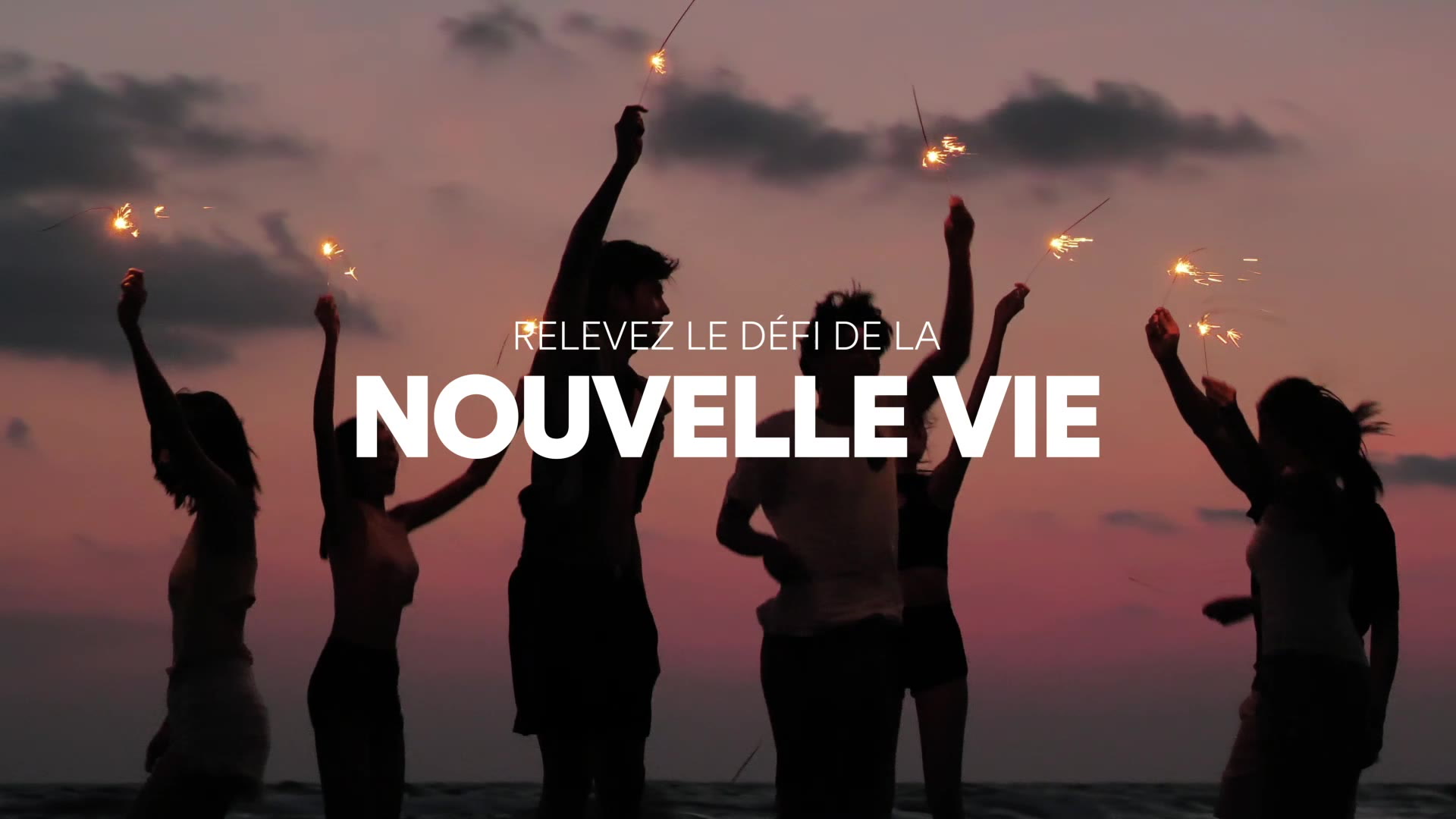 Silhouettes de personnes faisant la fête avec des cierges magiques sur une plage au coucher du soleil, avec les mots "Relevez le défi de la nouvelle vie" en gras et en blanc sur l'image.