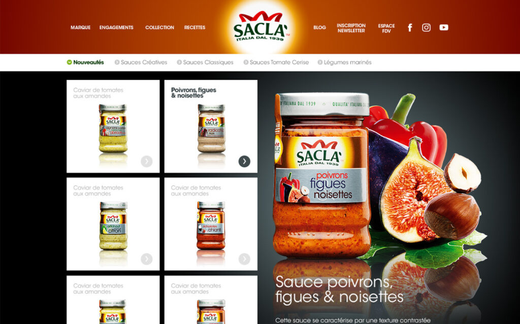 Capture d'écran du site Internet « Saclà création » présentant un grand bocal portant l'étiquette « Poivrons, figues & noisettes », entouré de poivrons et de figues, avec la liste des produits et les menus de navigation sur un fond blanc et orange.