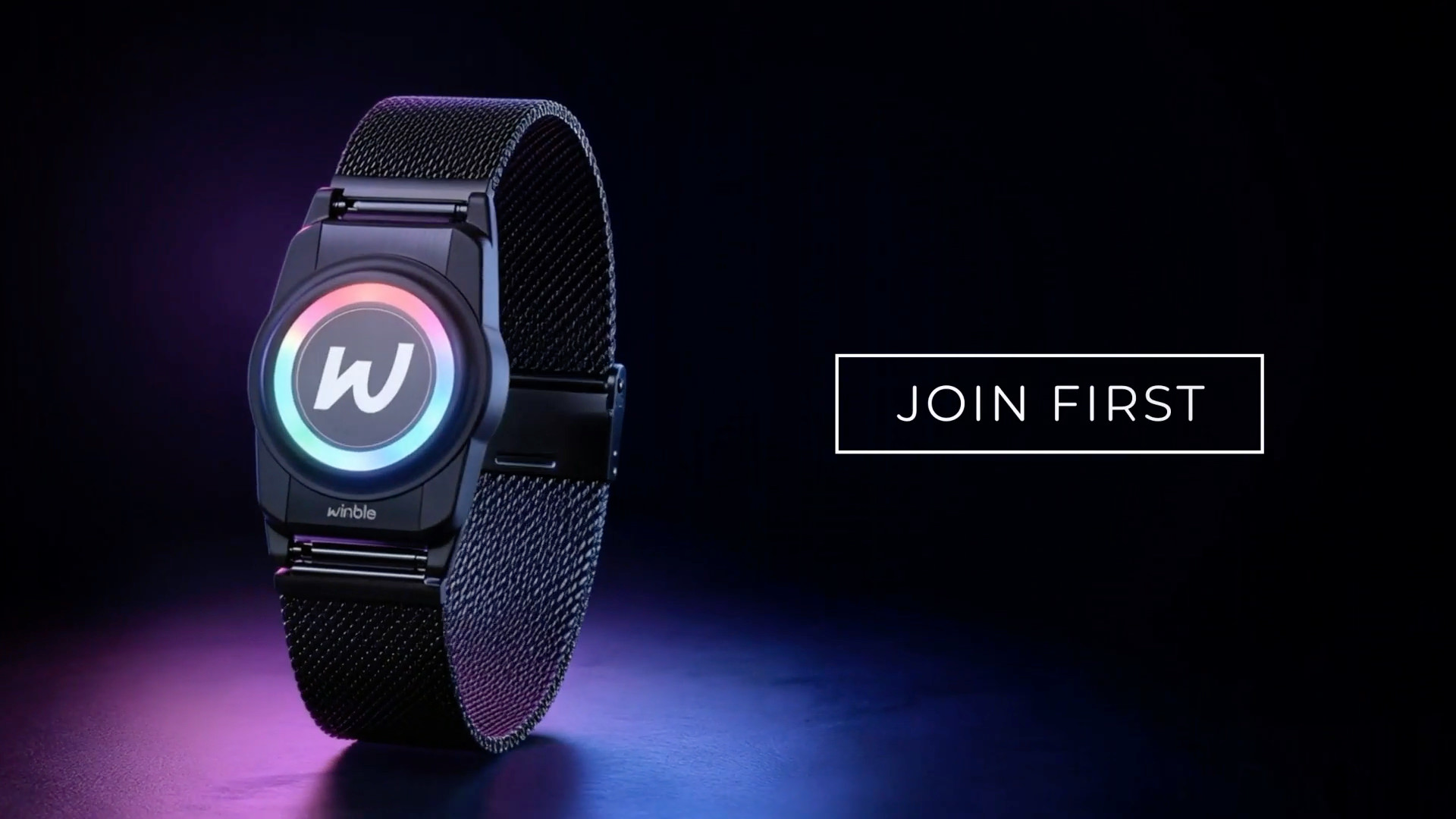 Un appareil portable noir, doté d'un écran circulaire lumineux et coloré, figure à côté de l'inscription « JOIN FIRST » sur un fond sombre.