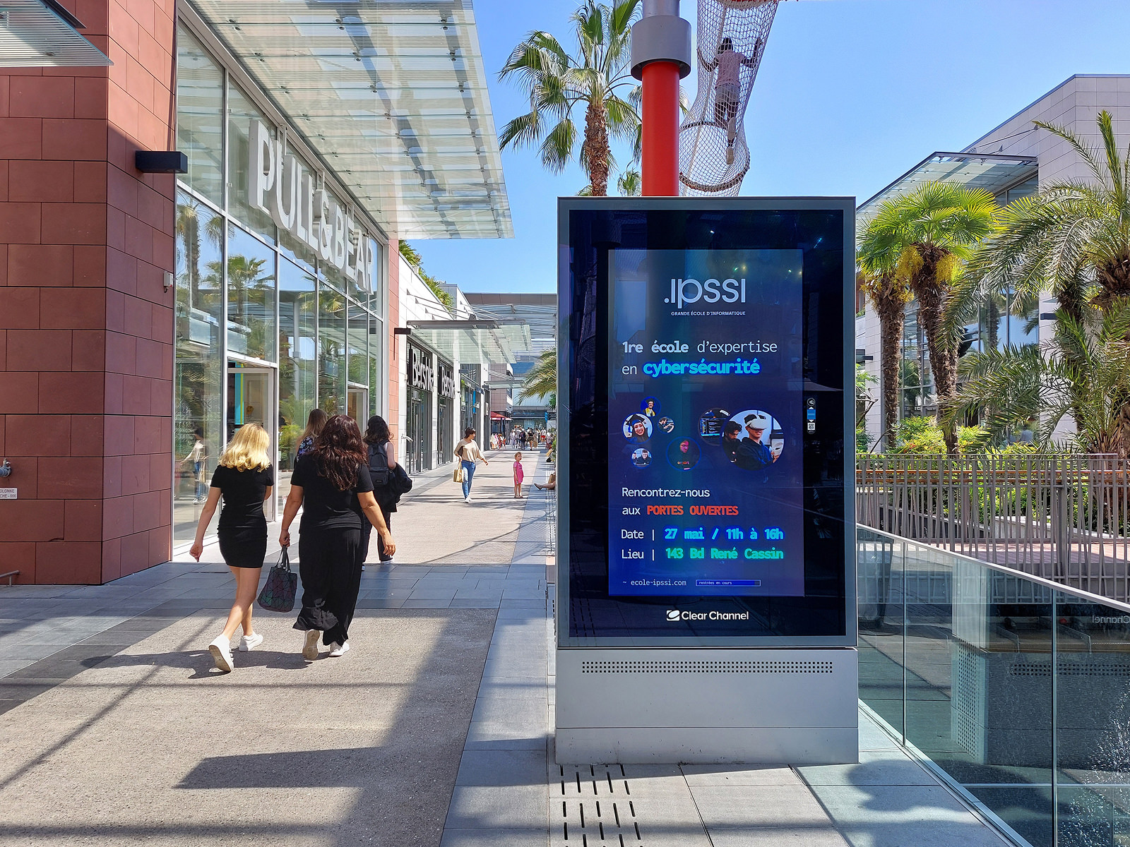 Écran numérique pour l'école de cybersécurité IPSSI, annonçant une journée portes ouvertes le 27 mai au 143, boulevard René Cassin, dans le cadre de notre campagne de communication sur l'enseignement supérieur, installé dans le passage d'un centre commercial.