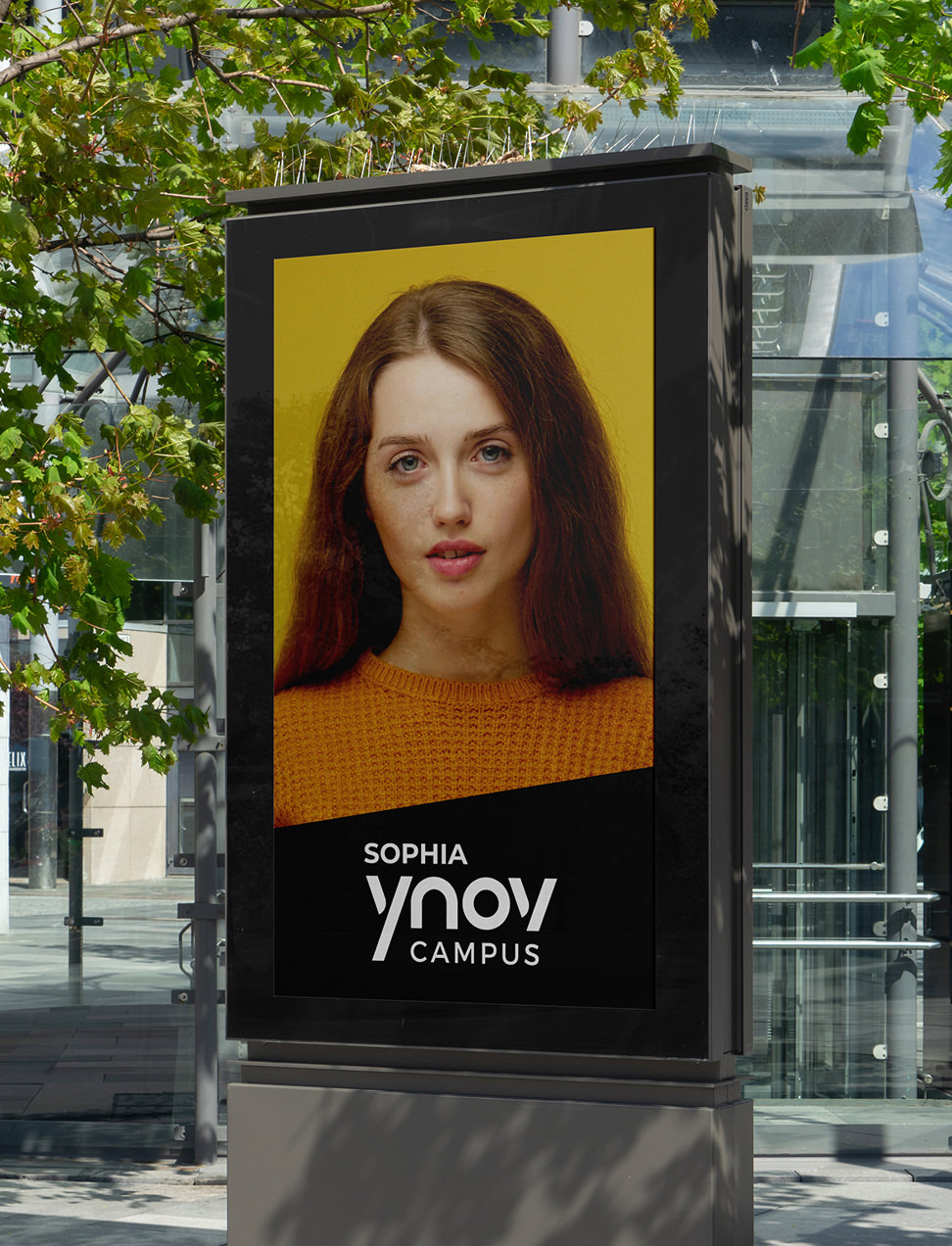 Panneau d'affichage extérieur représentant le portrait d'une femme au-dessus du texte « SOPHIA YNOV CAMPUS », destiné à la communication dans le domaine de l'enseignement supérieur.